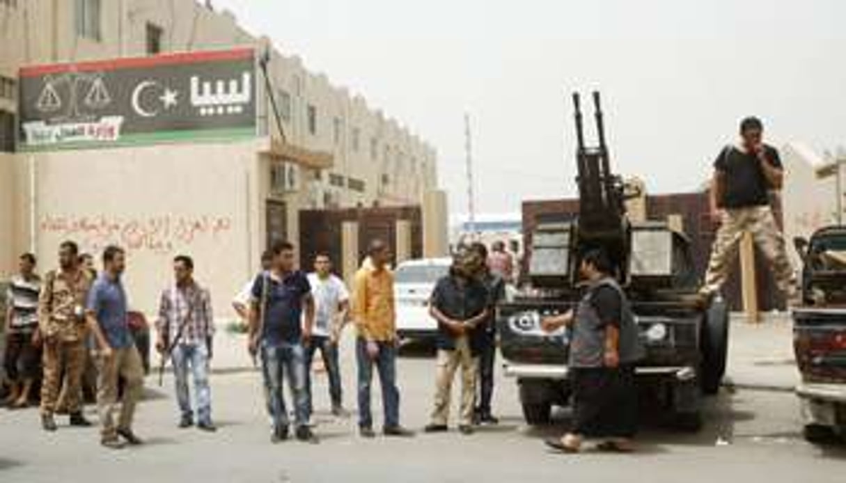 Des miliciens armés encerclant le ministère de la Justice, en avril 2013 à Tripoli. © Reuters