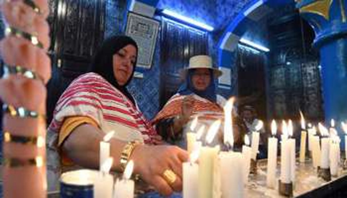 Des pèlerines juives allument des cierges dans la synagogue de la Ghriba, le 18 mai 2014. © AFP