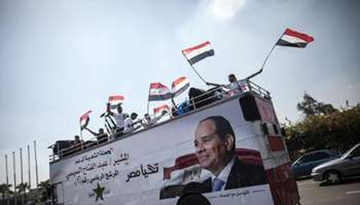 Des partisans du candidat al-Sissi défilent à bord d’un autobus au Caire, le 23 mai 2014. © AFP