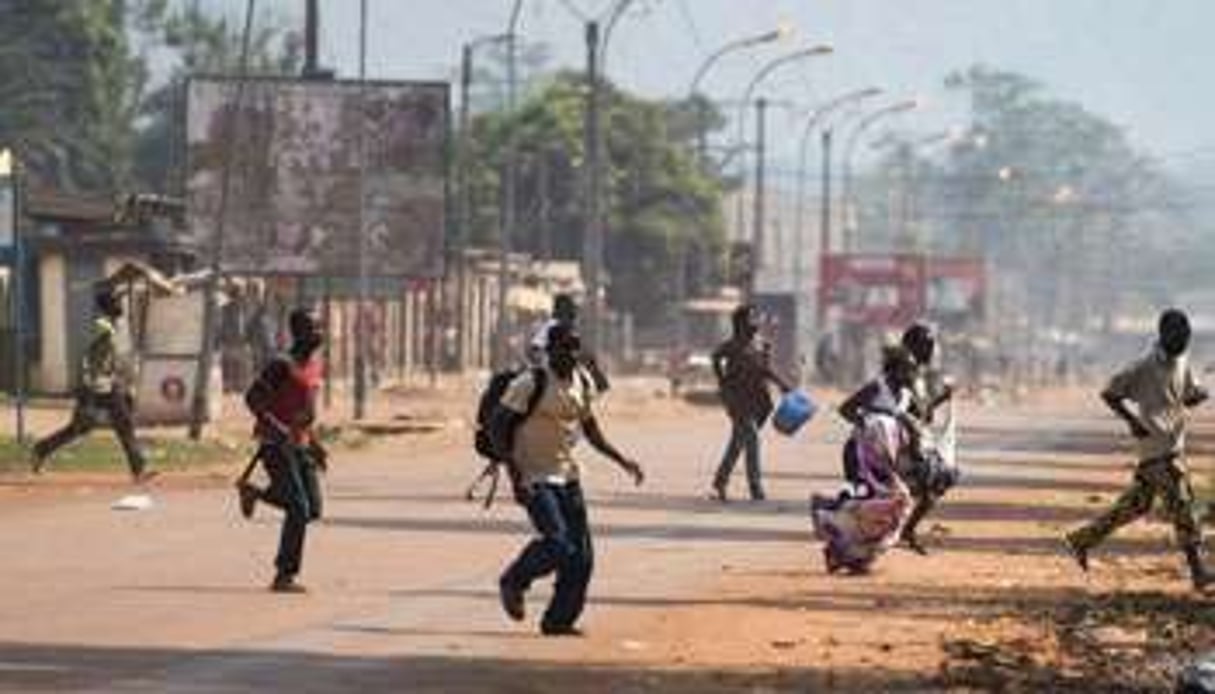 Des habitants de Bangui courent se mettre à l’abri alors que des tirs retentissent. © AFP