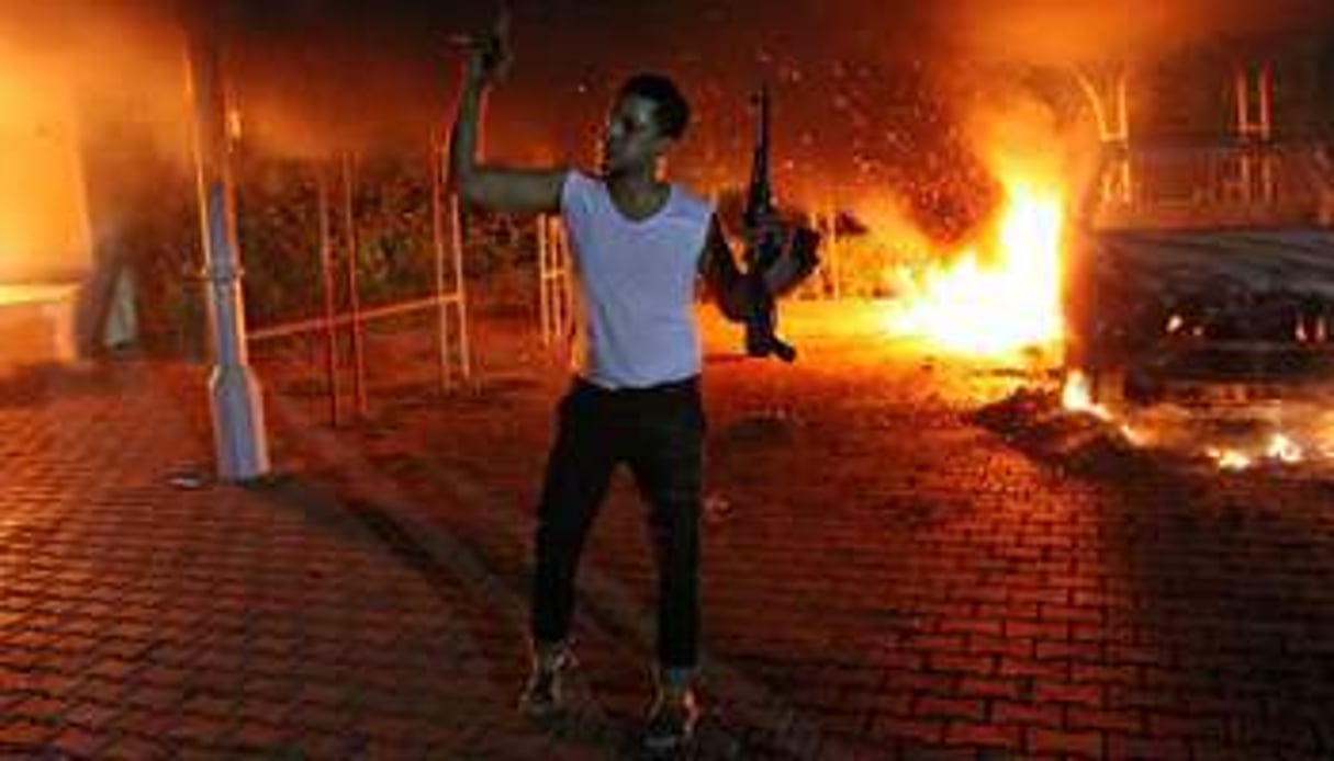 Un homme brandit une arme après l’attaque du consulat américain de Benghazi, le 11 septembre 2012. © AFP