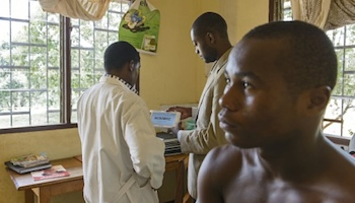 Le jeune lauréat Arthur Zang (centre) et un médecin testent le CardioPad sur un patient à l’hôpital Mbankomo, à 25 kilomètres de Yaoundé. © Rolex