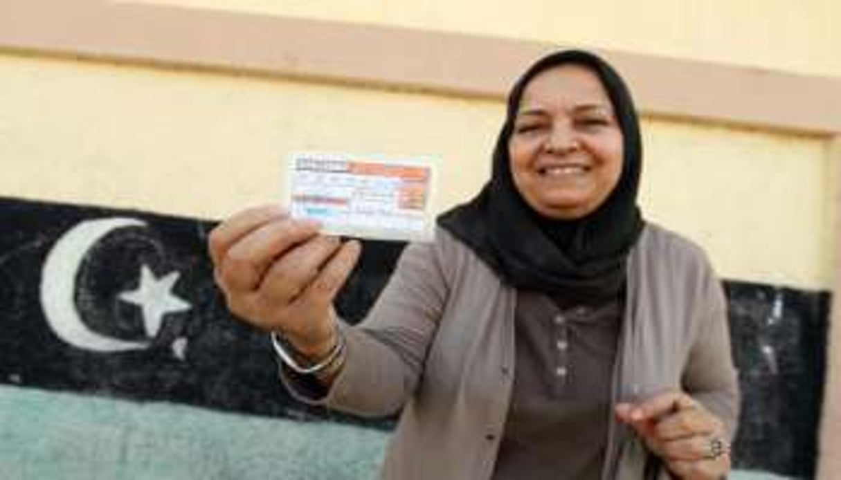 Une Libyenne montre sa carte d’électeur après avoir voté pour élire un nouveau Parlement. © AFP