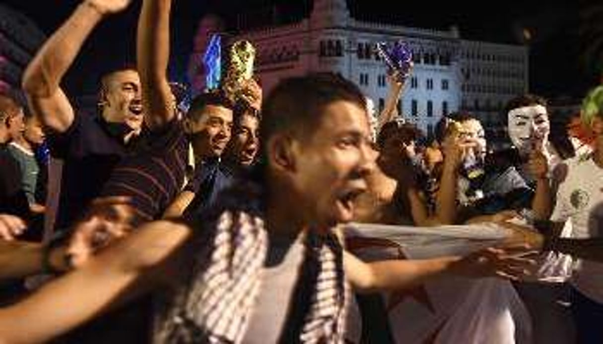 Des Algériens fêtent la qualification des Fennecs en 8ème de finale du Mondial à Alger. © AFP