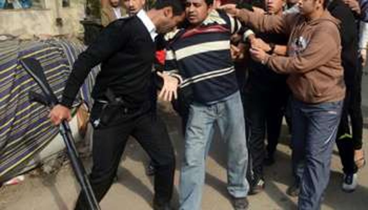 Un policier arrête un partisan des Frères musulmans, le 25 janvier 2014 au Caire. © AFP
