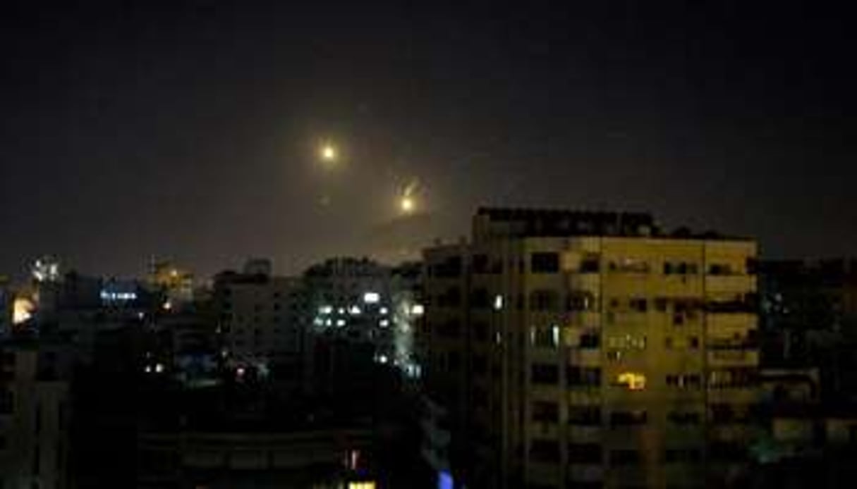 L’artillerie israélienne illumine le ciel de la ville de Gaza après un raid aérien le 8 juillet. © AFP
