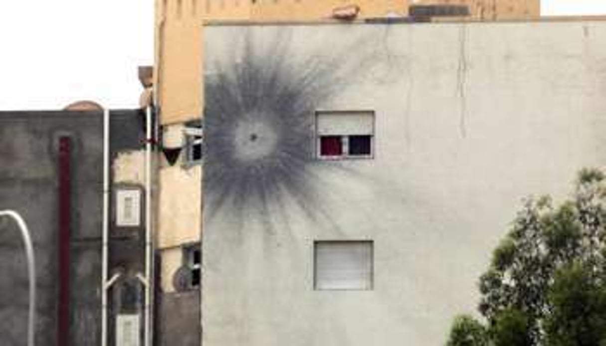L’impact d’une roquette sur le mur d’un immeuble le 19 mai 2014 près de l’aéroport de Tripoli. © AFP