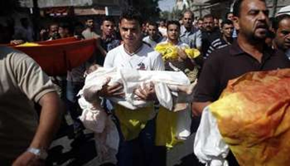 Un Palestinien pleure en portant le corps d’un bébé tué lors d’une frappe israélienne, à Gaza. © AFP