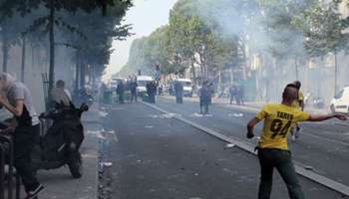 Un manifestant jette une pierre sur les policiers, le 19 juillet 2014 à Paris. © AFP
