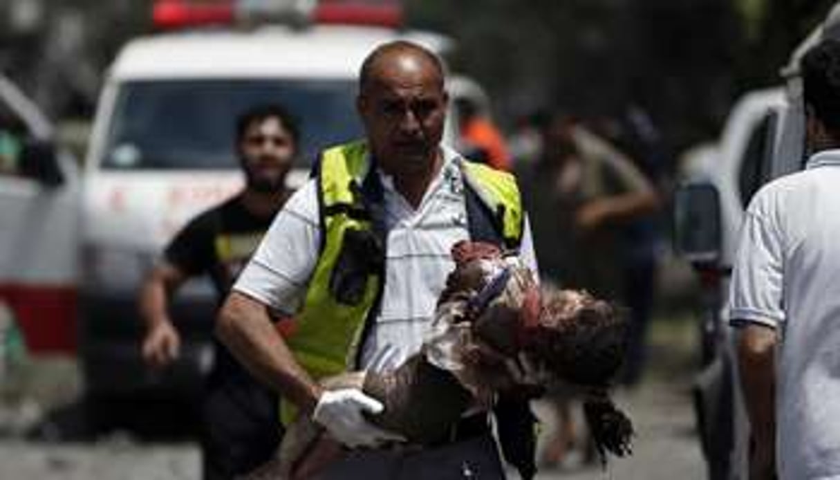 Un médecin palestinien évacue le corps d’une petite fille à Chajaya, en banlieue de Gaza. © AFP