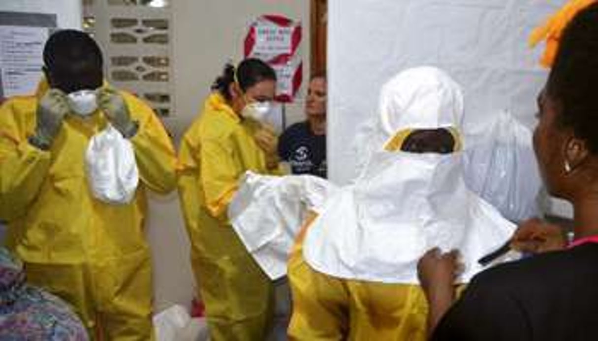 Le personnel d’un hôpital revêt des tenues de protection, le 24 juillet 2014 à Monrovia. © AFP