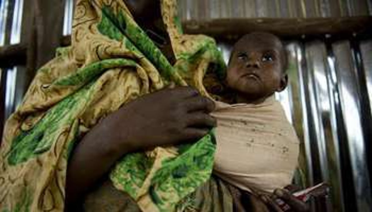 Un enfant et sa mère attendent de la distribution de nourriture à Dollow. © AFP