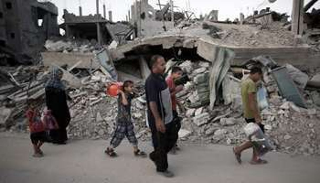 Des familles palestiniennes quittent leurs maisons détruites dans la bande de Gaza. © AFP