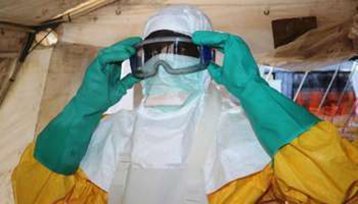 Un médecin revêt un équipement de protection avant de rencontrer un patient infecté par Ebola. © AFP