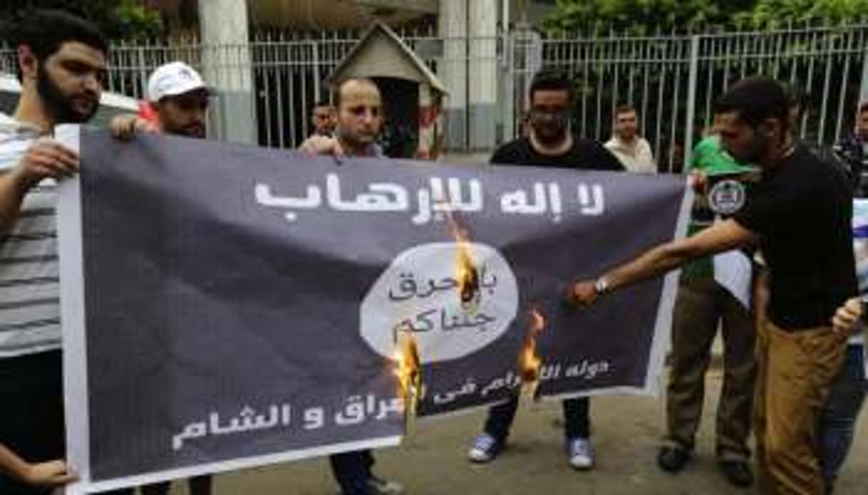 Des Libanais brûlent le drapeau de l’Etat islamique devant le ministère de la Justice. © ANWAR AMRO / AFP