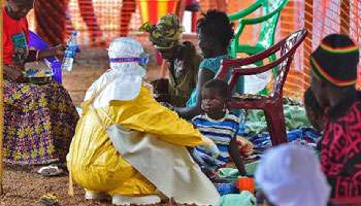 Un médecin de MSF examine un enfant contaminé par le virus Ebola. © AFP