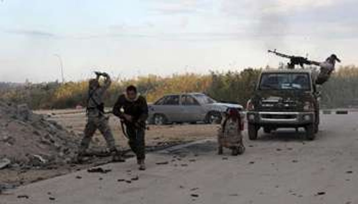 Des membres des forces armées libyennes tirent en direction de milices islamistes, le 3 novembre. © AFP