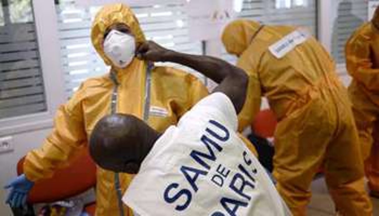 Du personnel médical s’équipent avec une tenue de protection contre Ebola, à Paris. © AFP