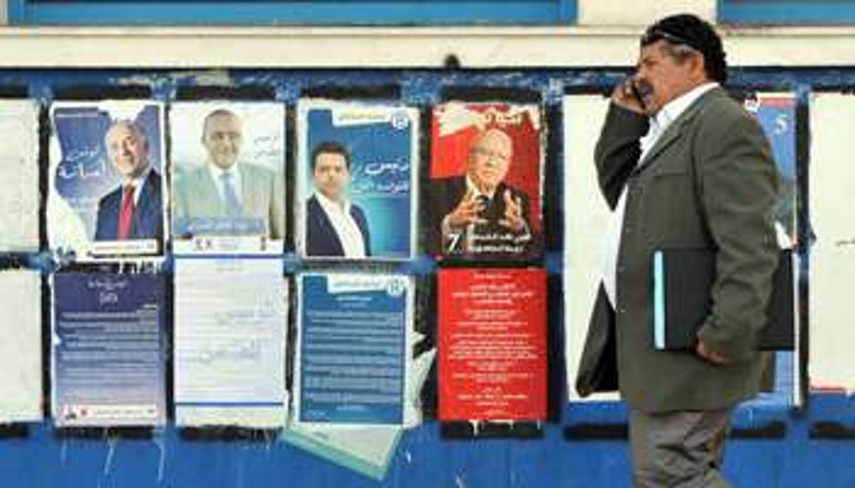 Un homme devant les affiches de la campagne présidentielle, à Tunis, le 20 novembre 2014. © Fethi Belaid/AFP