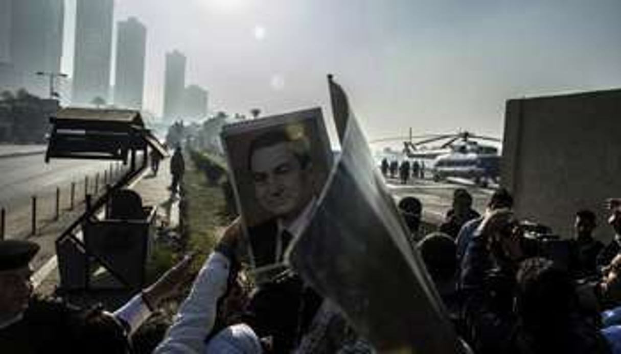 Des partisans de Hosni Moubarak brandissent des portraits du raïs, le 29 novembre 2014. © AFP