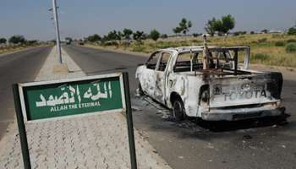 Une voiture de police brûlée est abandonnée sur une route à Damaturu, au Nigeria, en 2011. © AFP