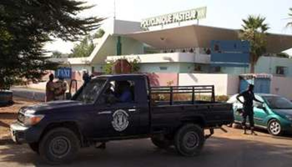 Des policiers montent la garde devant une clinique de Bamako. © AFP