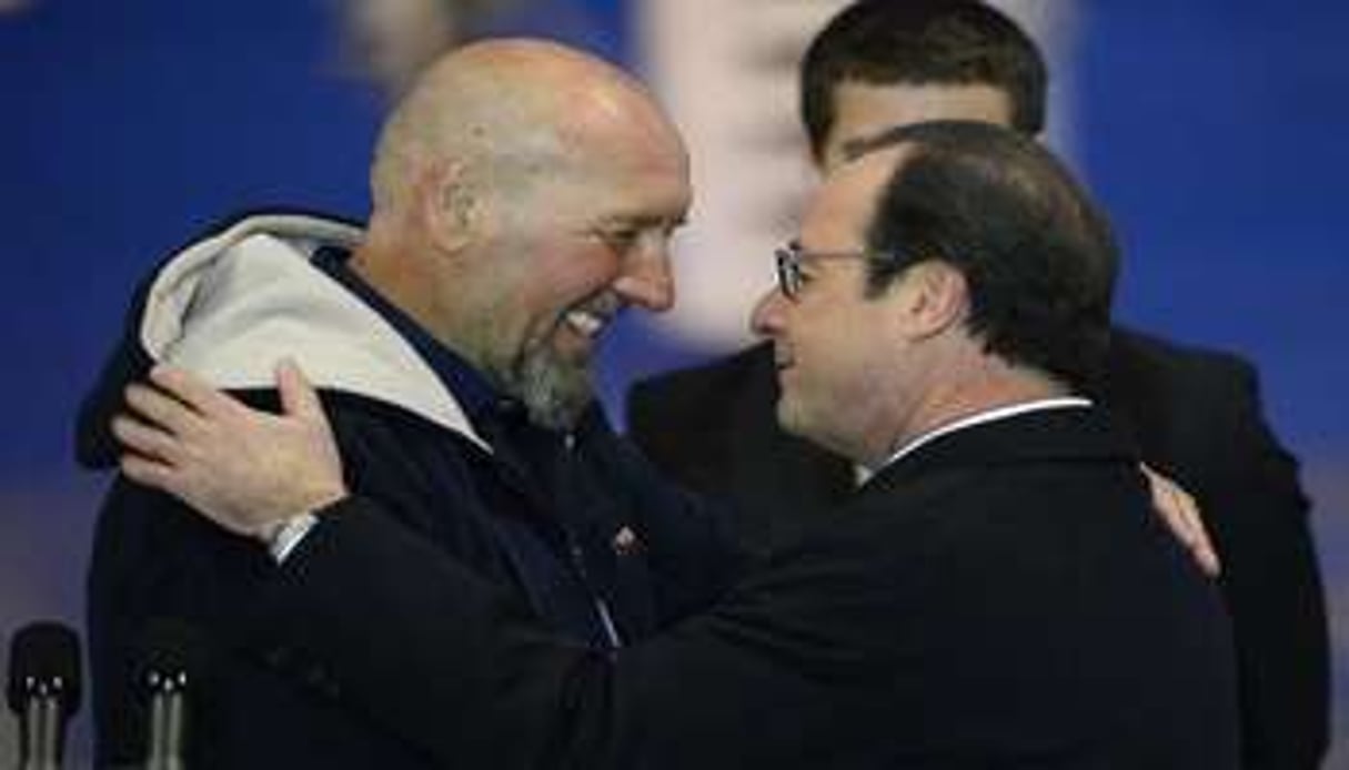 Serge Lazarevic (à gauche) embrasse le président François Hollande sur le tarmac de Villacoublay © AFP