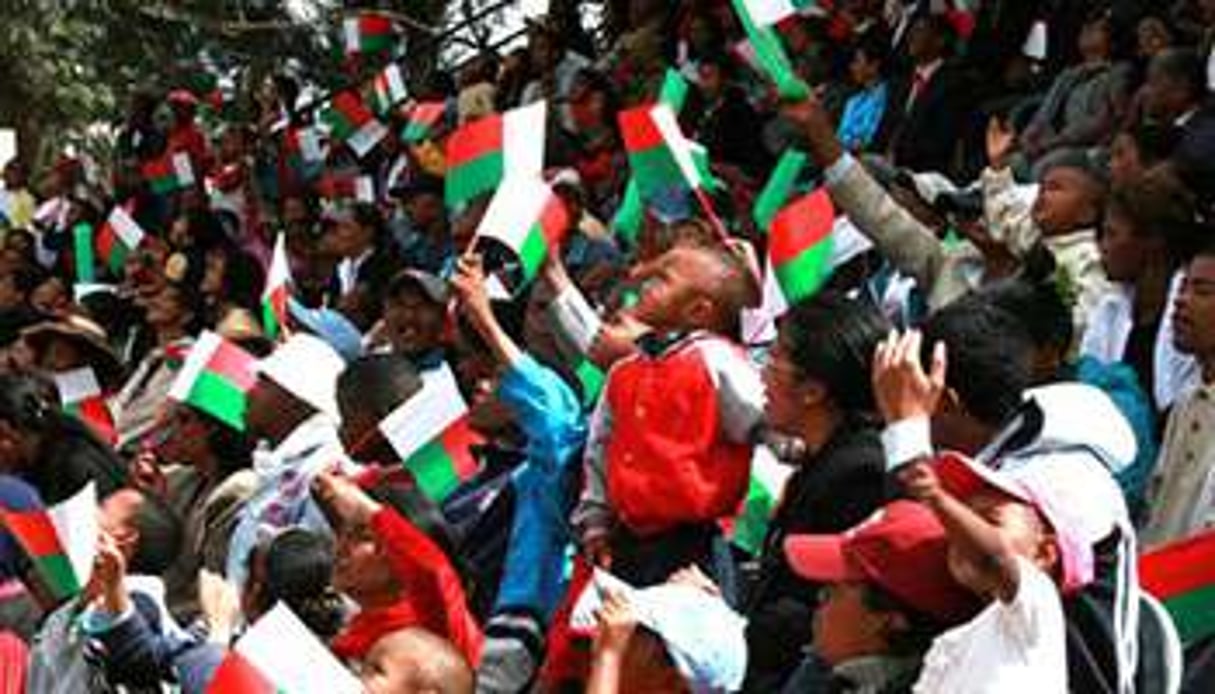 Des Malgaches brandissent leur drapeau national. © AFP