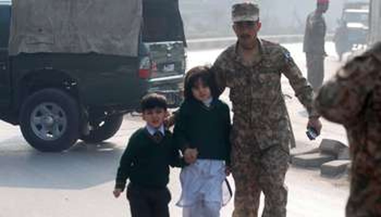 Des élèves pakistanais s’éloignent de l’école attaquée, le 16 décembre à Peshawar. © Reuters