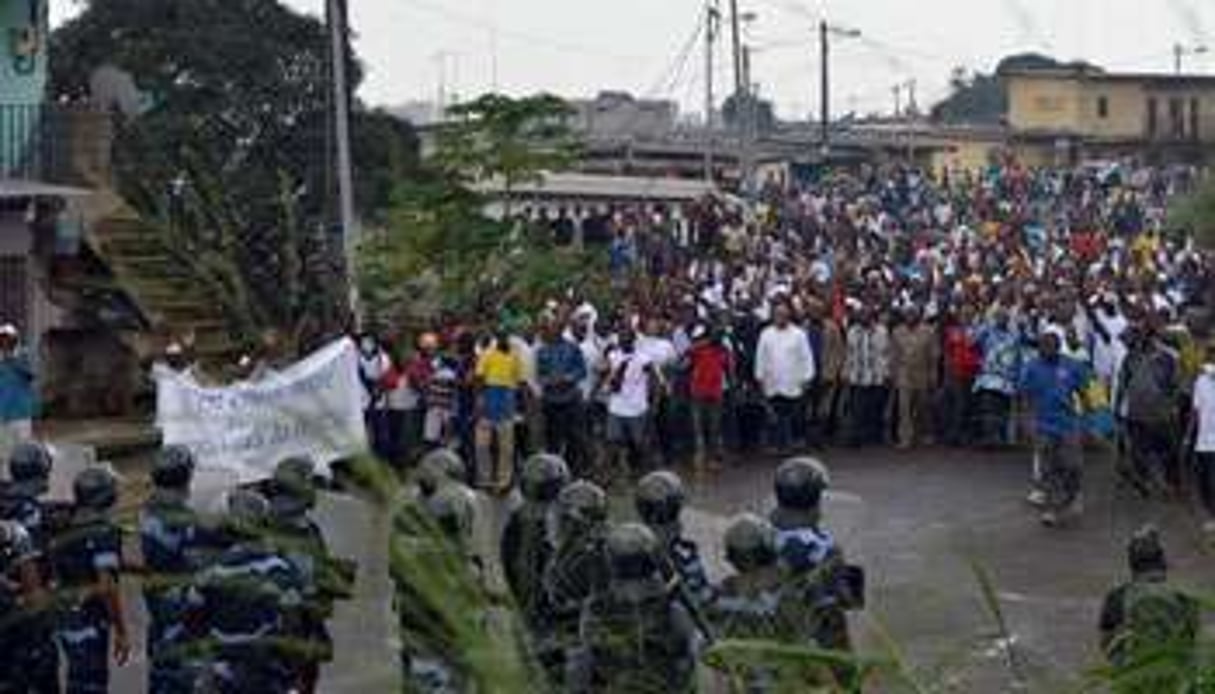 Policiers et manifestants face à face le 20 décembre à Libreville. © AFP