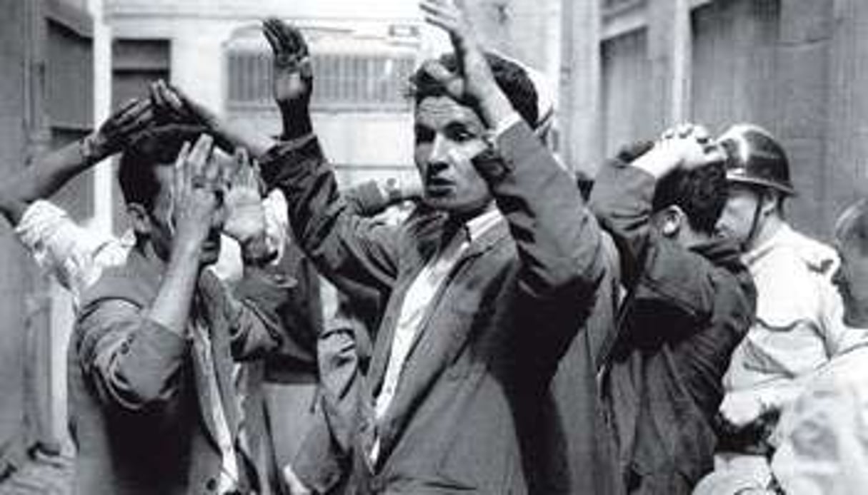 Des Algériens arrêtés après l’explosion d’une bombe, dans une rue de Constantine, en 1955. © AFP