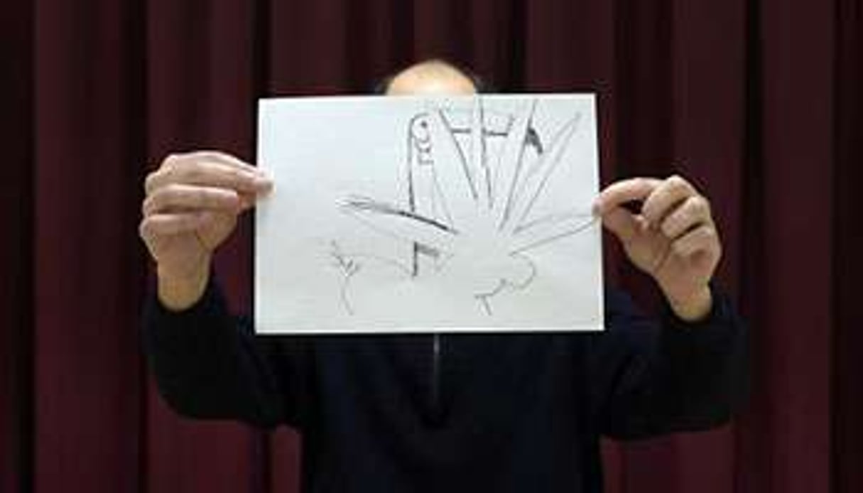 Le caricaturiste ‘Z’ derrière un de ses dessins, le 16 janvier 2015 à Paris. © AFP