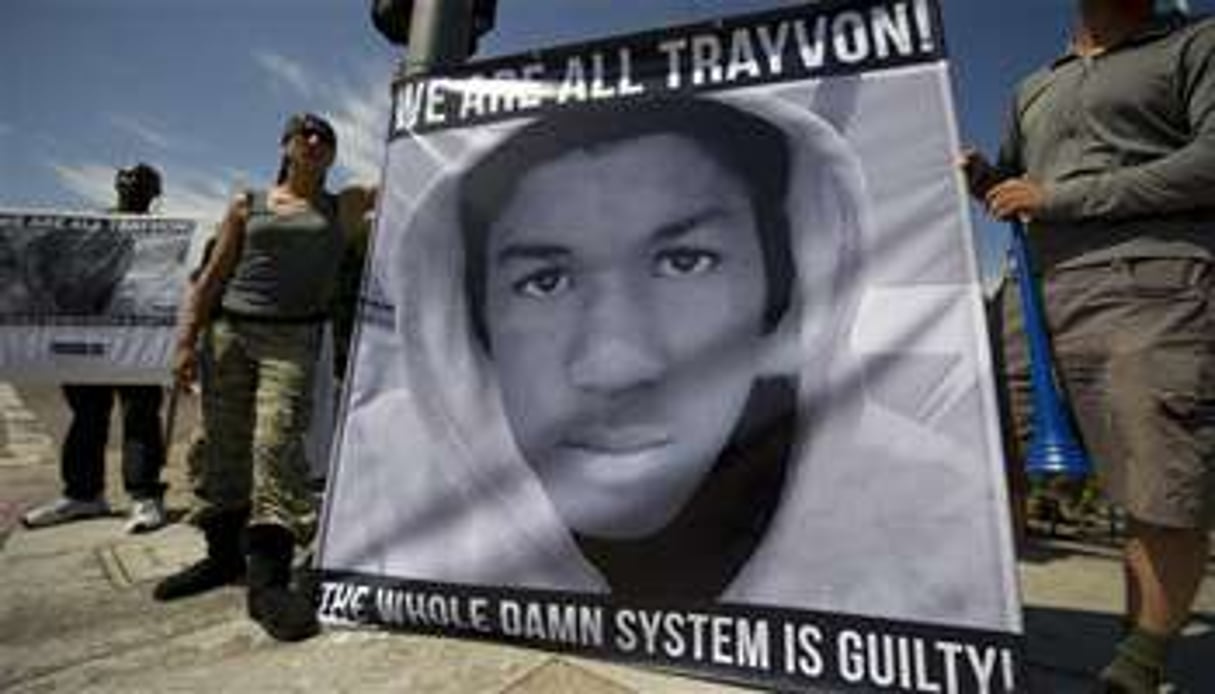 Des manifestants tiennent une banderole à l’effigie de Trayvon Martin. © Robyn Beck/AFP