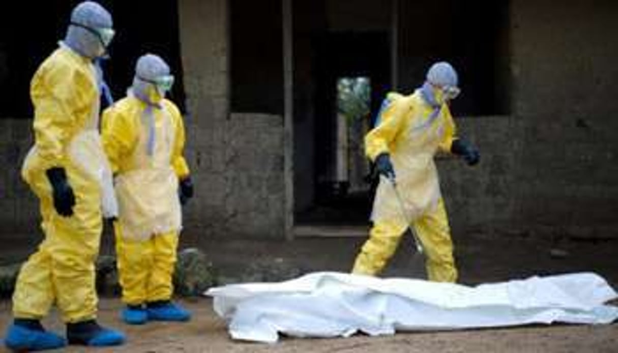 Des soignants autour du cadavre d’une victime d’Ebola. © AFP