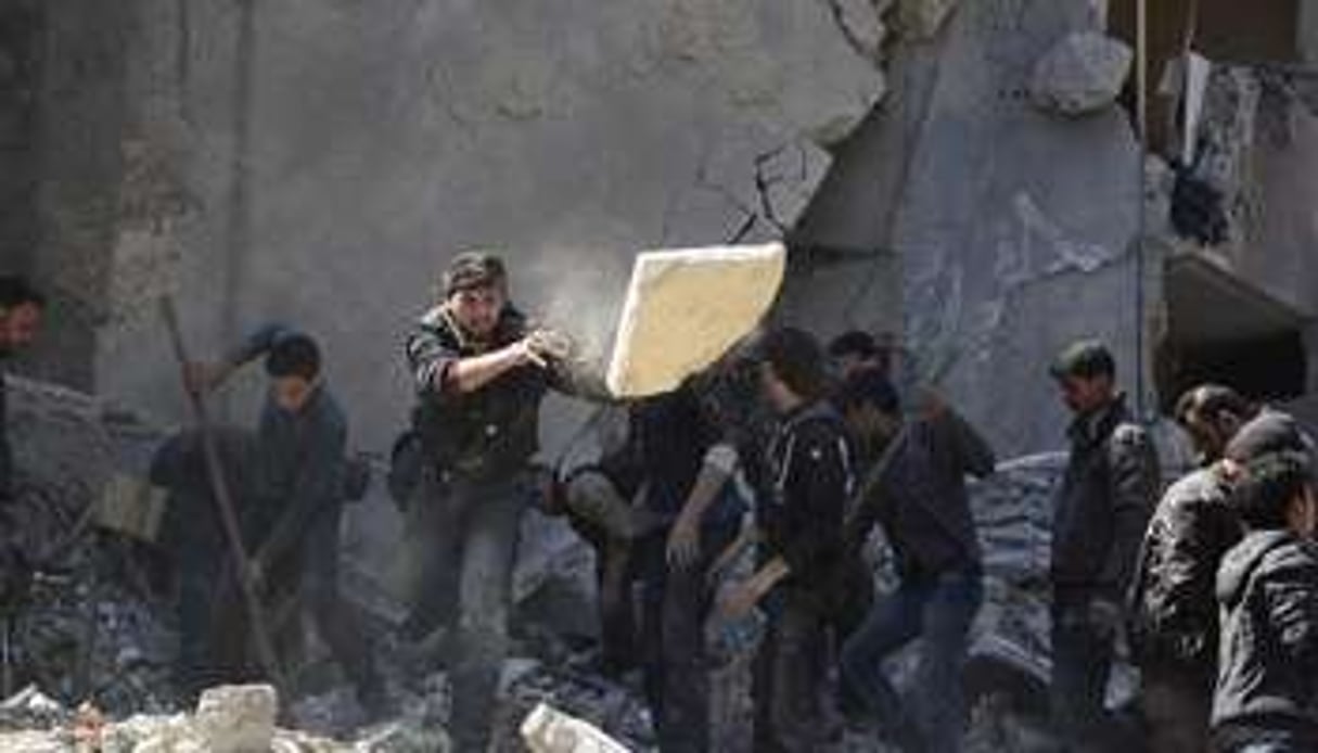 Des Syriens fouillent les décombres d’un immeuble à la recherche de victimes le 13 mars. © Sameer al-Doumy / AFP