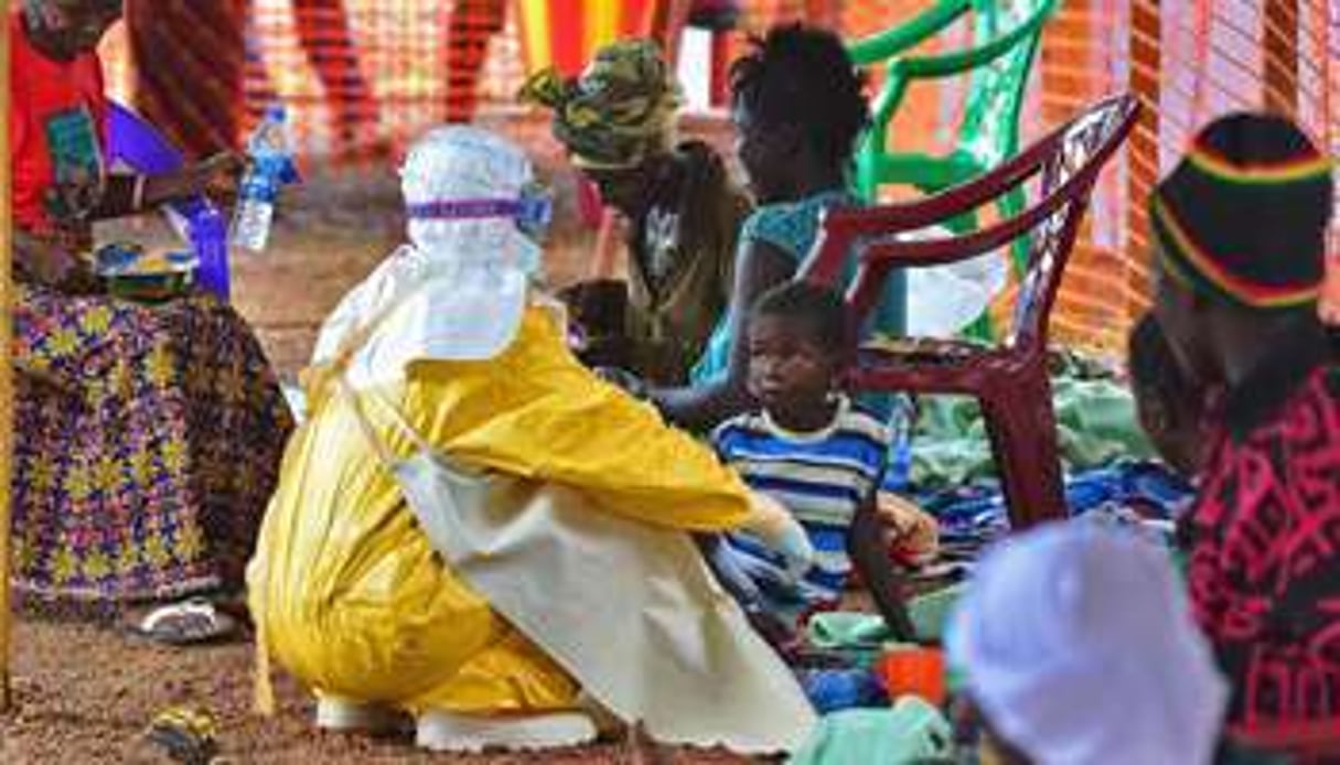 Un employé de MSF nourrit un enfant victime du virus Ebola, le 15 août à Kailahun. © AFP