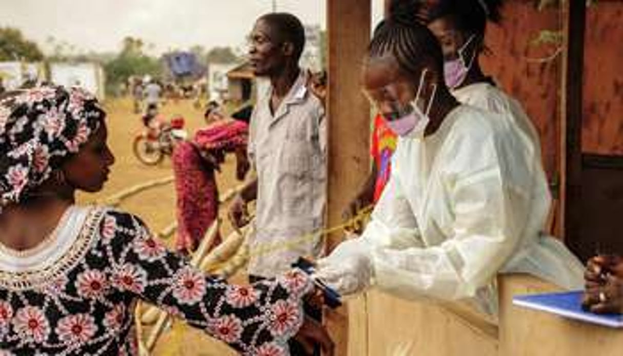 Des personnels de santé de Sierra Leone à la frontière avec le Libéria à Jendema le 28 mars. © AFP