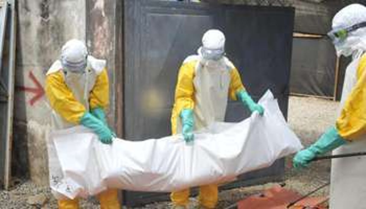 Du personnel de la Croix Rouge guinéenne retire le corps d’un patient décédé du virus de l’Ebola © AFP