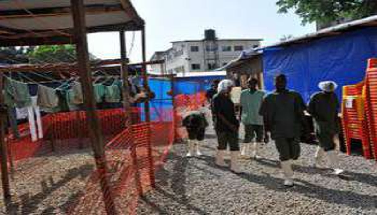 Des travailleurs de santé portent des tenues anti-Ebola dans un centre de traitement à Conakry. © AFP