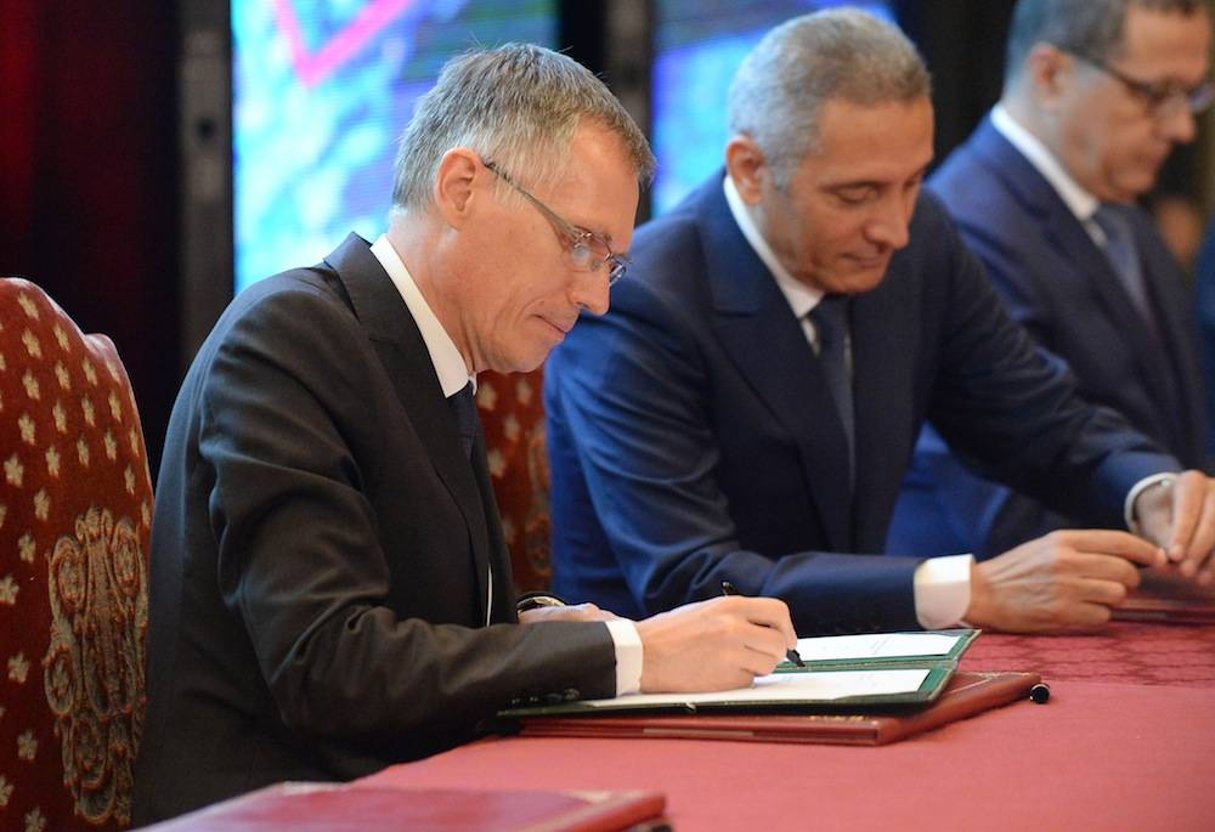 Moulay Hafid El Alamy, Carlos Tavares, le directeur général de PSA Peugeot Citroën, signe l’accord industriel d’installation d’une usine au Maroc en 2019. © AFP