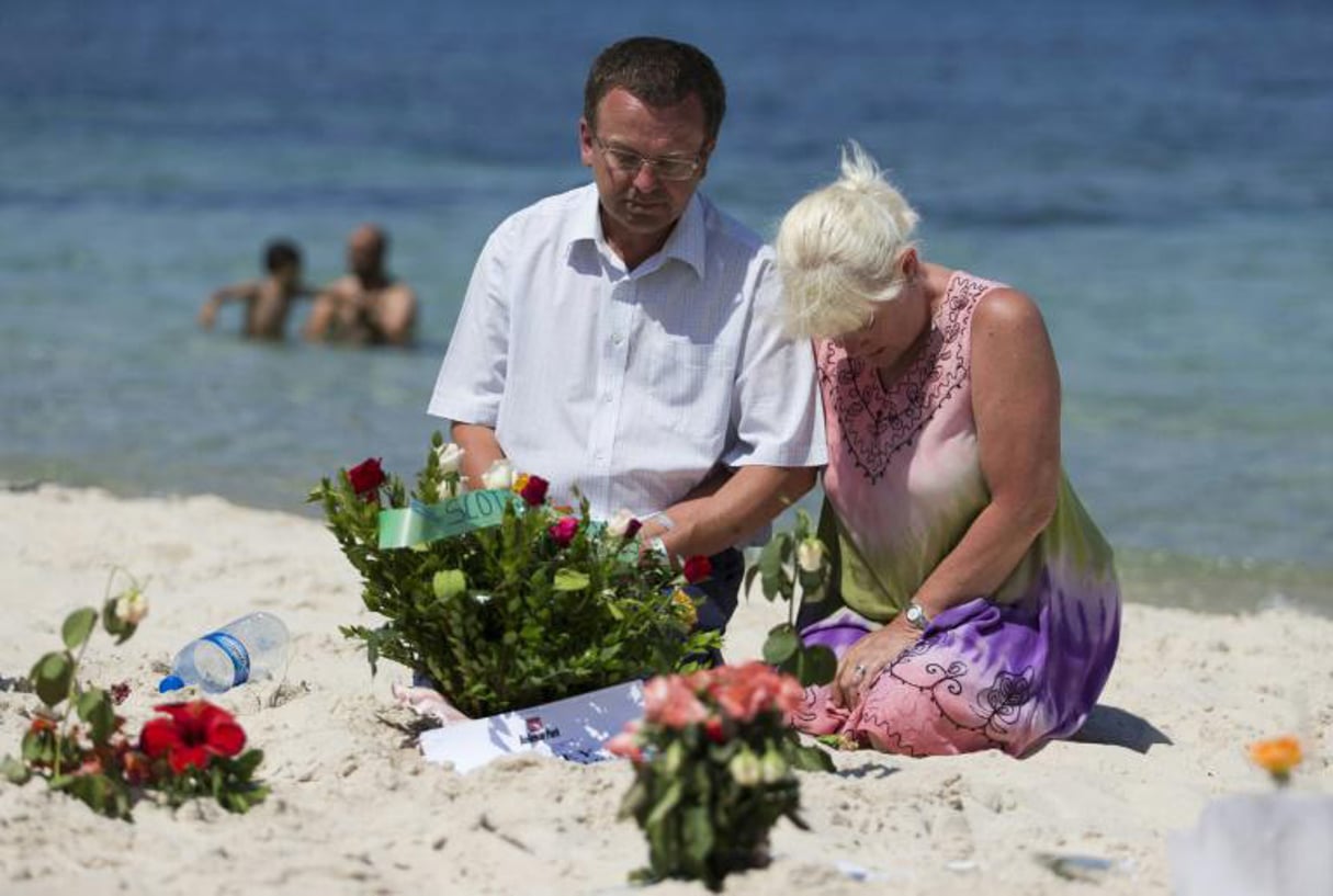 Des touristes se recueillent sur la plage de Sousse le 28 juin 2015 après l’attaque qui a fait 38 morts. © Kenzo Tribouillard/AFP