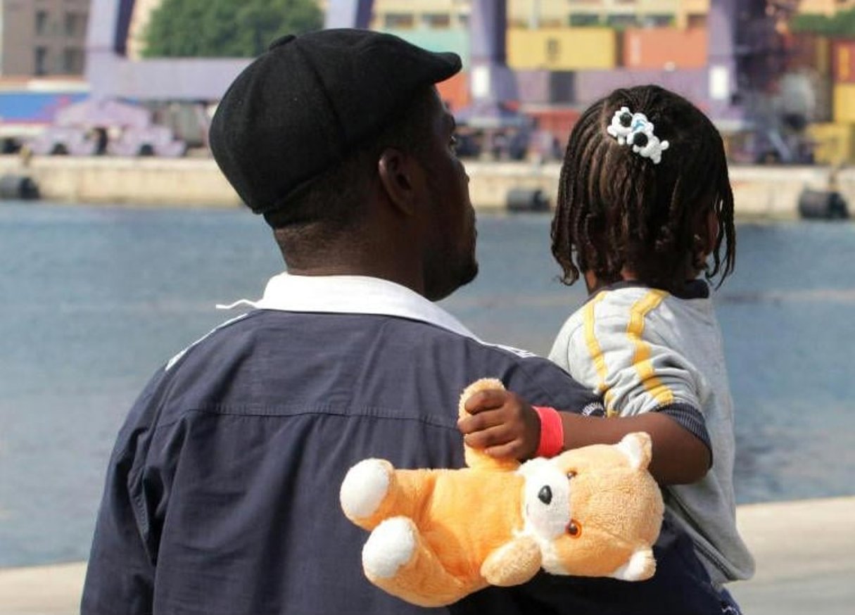 Un migrant et sa fille dans le port de Palerme, le 11 juillet 2015. © Marcello Paternotro/AFP