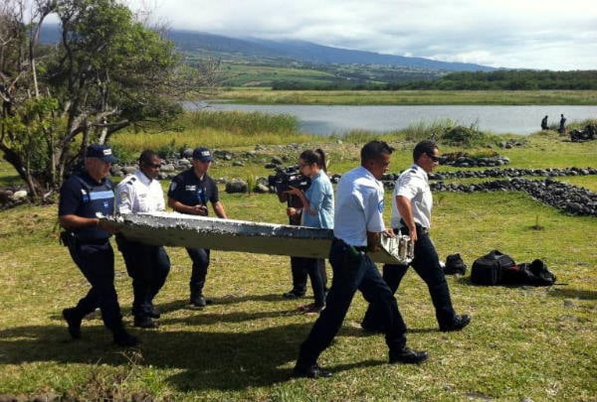 La police porte un débris d’avion non identifié, retrouvé sur la côte de Saint-André de la Réunion, le 29 juillet 2015. © Yannick Piton/AFP
