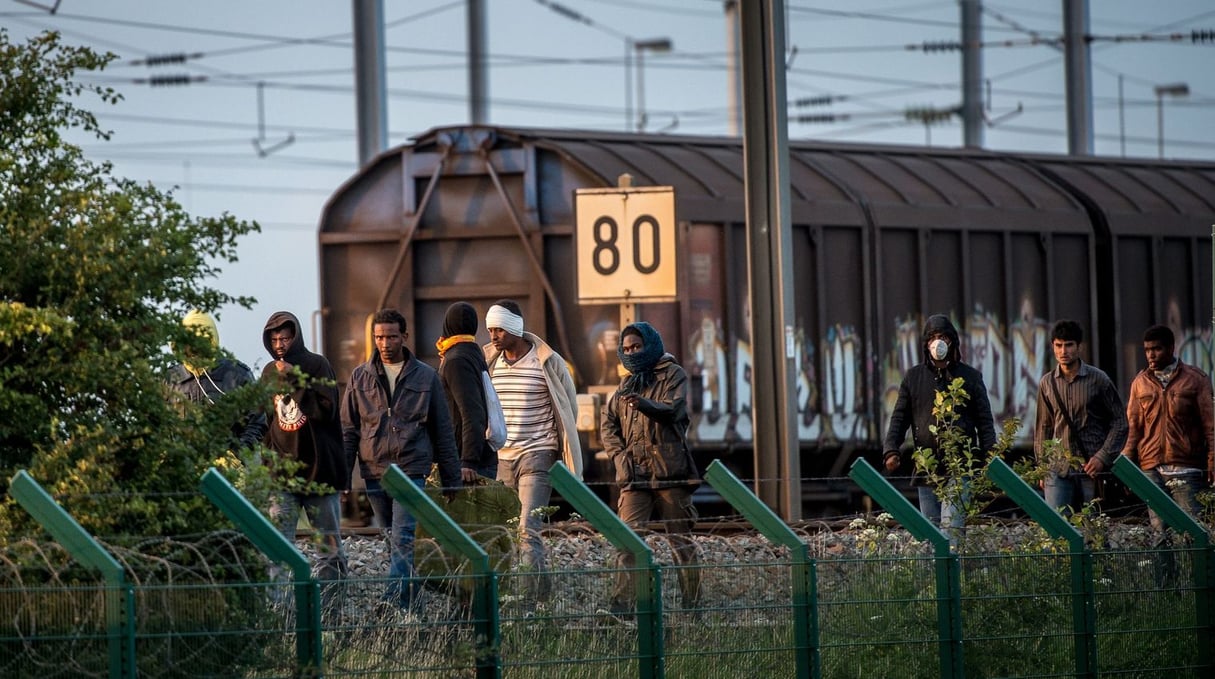 Des migrants sur le site d’Eurotunnel à Calais pour tenter de passer en Grande-Bretagne. © AFP/Philippe Huguen