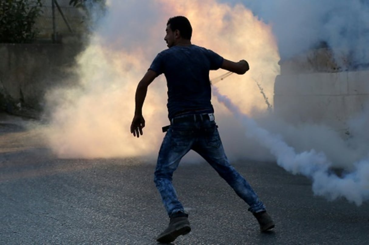 Un manifestant palestinien utilise un lance-pierres face aux forces antiémeutes israéliennes, le 31 juillet 2015. © AFP