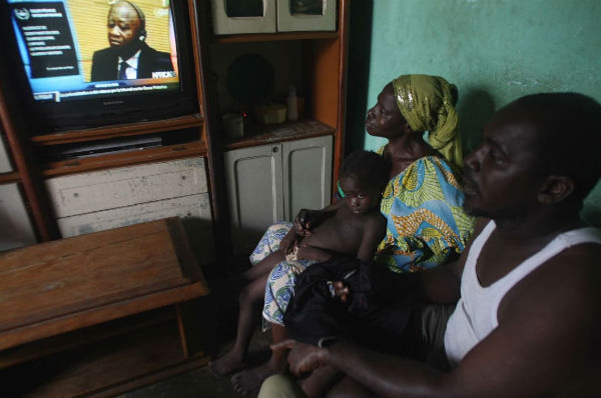 Adama Fofana, dont les deux frères ont été tués dans les violences postélectorales, regarde le procès du président Laurent Gbagbo, dans sa maison d’Abidjan, le 19 février 2013. © Emanuel Ekra/AP/SIPA