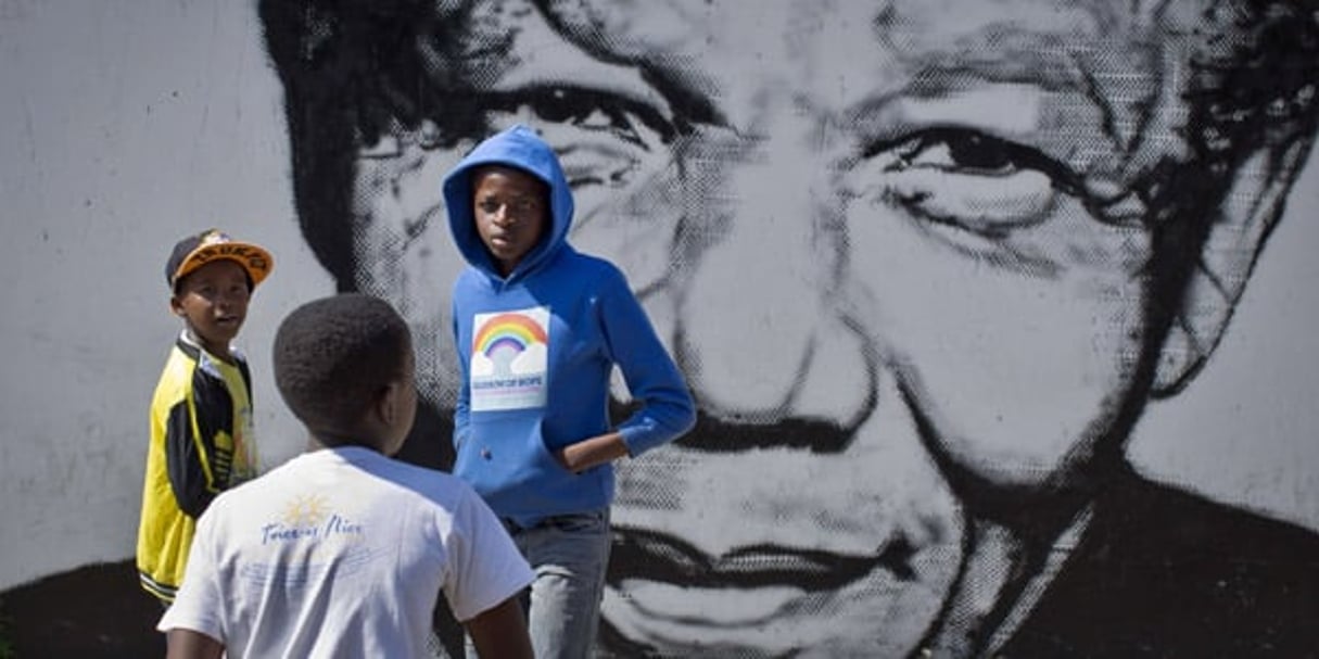 Trois jeunes sud-africains devant une fresque murale représentant Nelson Mandela, le  2 mai 2014 à Soweto. © Ben Curtis/AP/SIPA