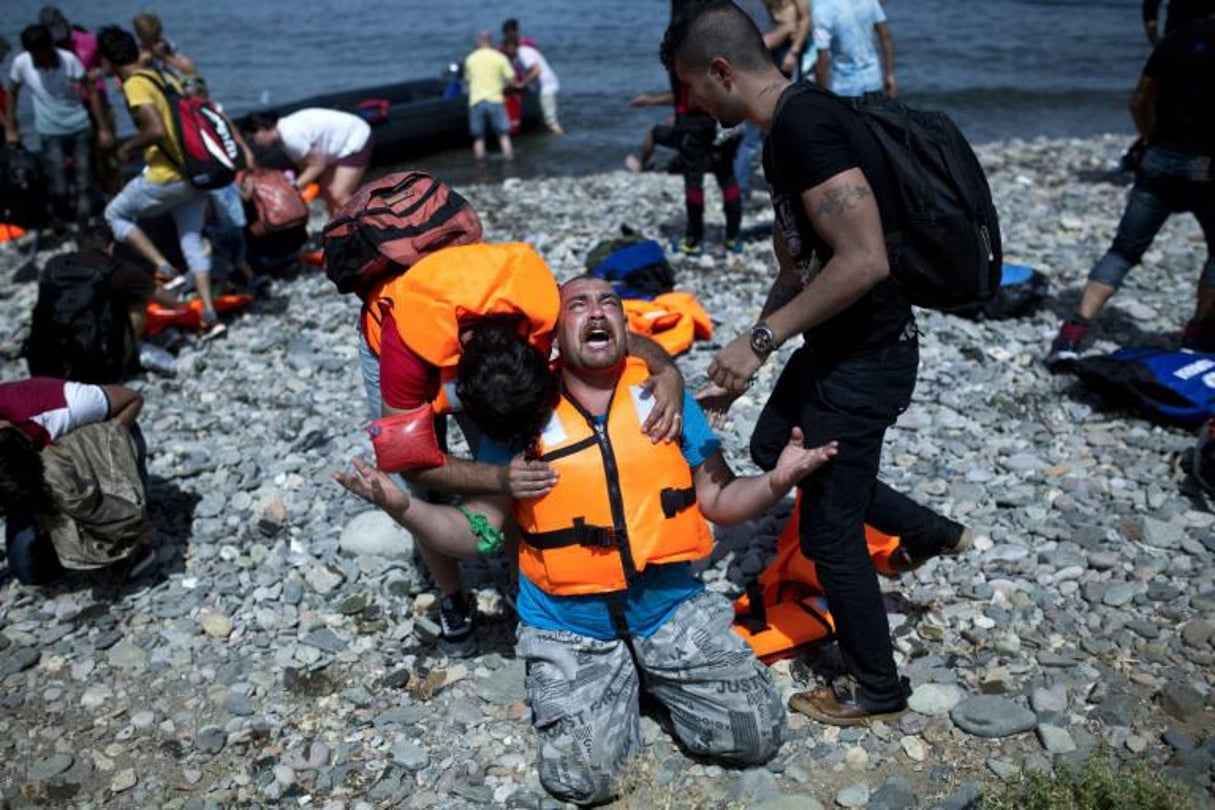Un réfugé syrien prie après être arrivé sur l’île grecque de Lesbos, le 7 septembre 2015. © AFP