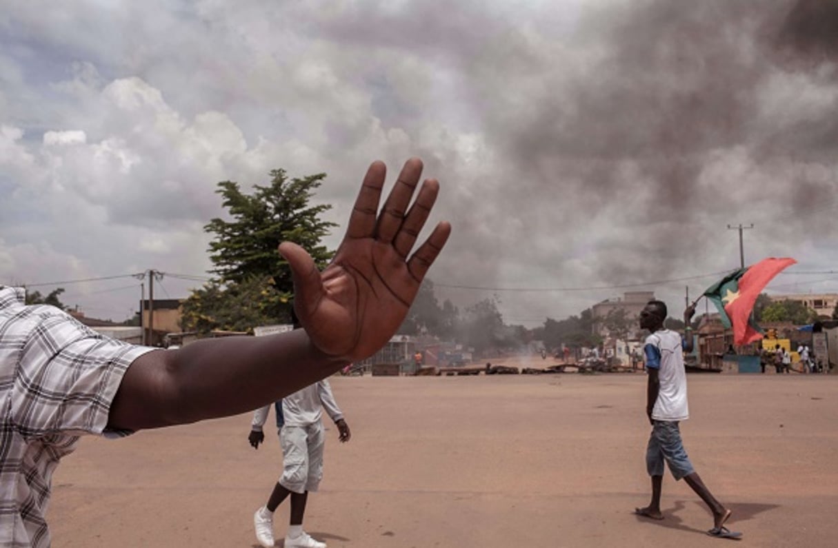 Un manifestant le 22 septembre à Ouagadougou tenant un drapeau burkinabè. © Theo Renaut/AP/SIPA