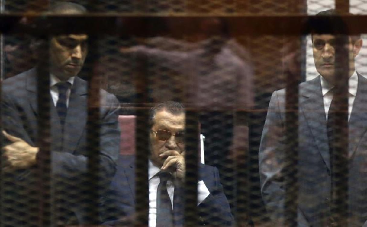 L’ex-président Hosni Moubarak (c) et ses fils Gamal (g) et Alaa dans la cage des accusés, lors de leur procès pour corruption, le 9 mai 2015 au Caire. © AFP